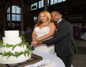 Mr. & Mrs. Corey & Erika Jackson cutting wedding cake.